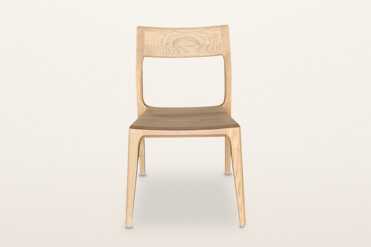 Cison dining chair in Natural, front view on a warm white studio backdrop: the wide backrest on top of the posts