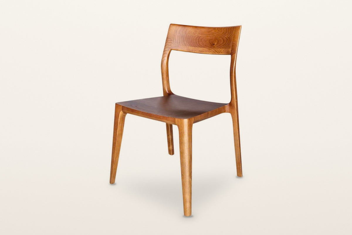 Cison dining chair in Warm Brown, three-quarter view on a warm white studio backdrop