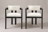 A set of two Cisternino dining armchairs in Black with ivory boucle seats, straight front view on a studio backdrop