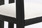 Close-up of the ivory boucle seat, the square front leg and the black wire-brushed wood frame of the Cisternino chair