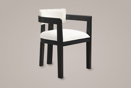 Cisternino dining armchair in Black with an ivory boucle seat, three-quarter view on a warm grey studio backdrop