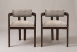 A set of two Cisternino dining armchairs in Espresso with light brown boucle seats, straight front view on a studio backdrop