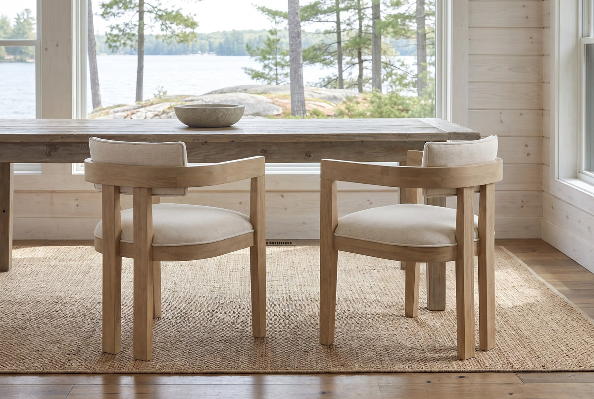 Two Cisternino chairs at a pine table in a Muskoka cottage with a window onto the lake