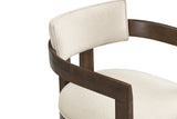 Close-up of the flat walnut arm rail curving round behind the slim beige linen-look back pad of the Cisternino chair
