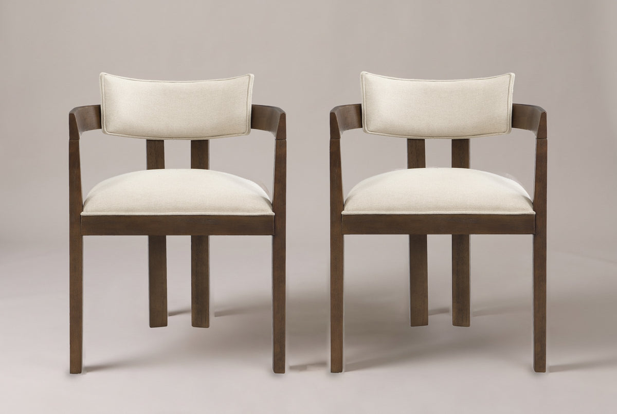 A set of two Cisternino dining armchairs in Walnut with beige linen-look seats, straight front view on a studio backdrop