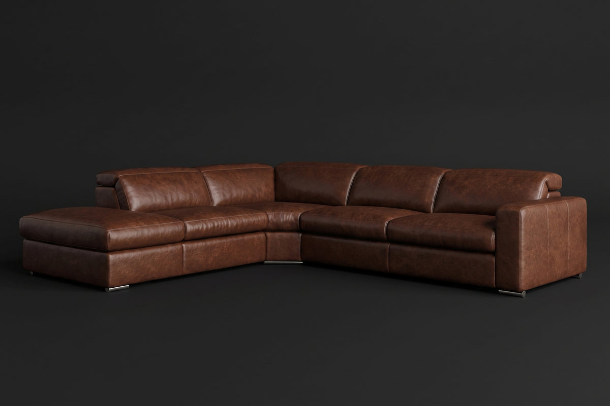 The Clara sectional against a dark studio backdrop, headrests down, the chaise on the left. Shown in distressed full-aniline leather, Burnished Chestnut, Left bumper.