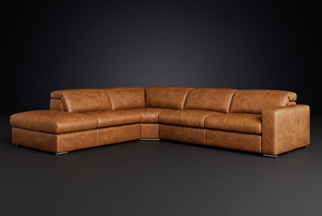 The Clara sectional against a dark studio backdrop, headrests down, the chaise on the left. Shown in distressed full-aniline leather, Antiqued Caramel, Left bumper.