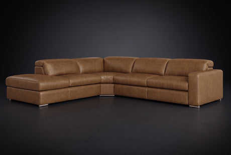 The Clara sectional against a dark studio backdrop, headrests down, the chaise on the left. Shown in distressed full-aniline leather, Weathered Saddle, Left bumper.
