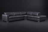 The Clara sectional against a dark studio backdrop, headrests down, the chaise on the right. Shown in distressed full-aniline leather, Aged Slate, Right bumper.