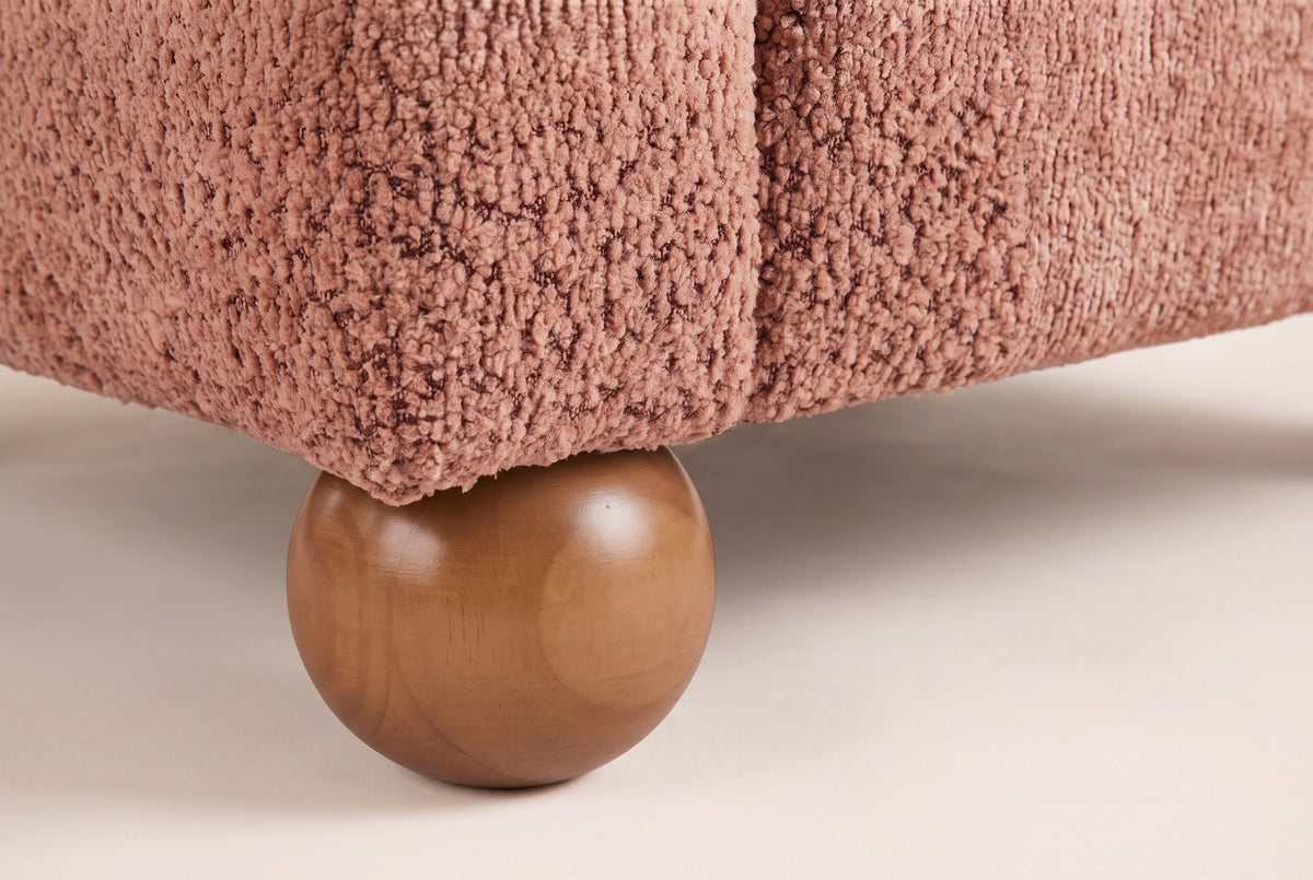 Close-up of a solid wood ball foot under the Coral upholstered corner of the Collodi chair