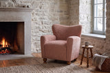 Collodi chair in Coral in a Quebec City stone sitting room with a low fire, a turned stool and snowy daylight