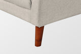 Close-up of the beige front corner and a tapered solid wood leg in a walnut finish