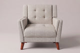 Comacchio armchair in beige, straight front view: tufted back between two upright posts, flared track arms