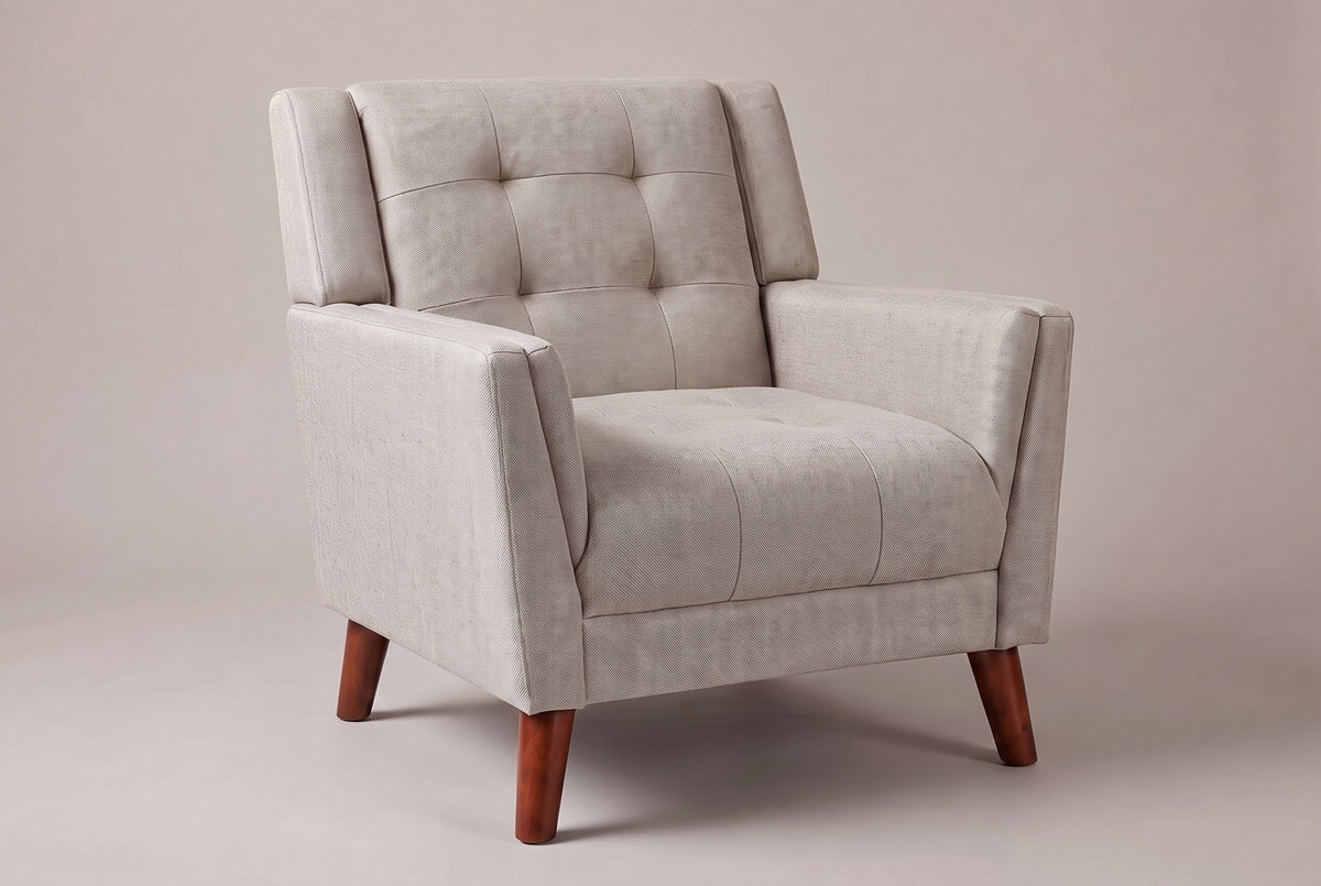 Comacchio tufted mid-century armchair in beige, three-quarter view on a warm grey studio backdrop
