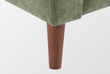 Close-up of a tapered solid wood leg in a walnut finish under the green chenille front corner
