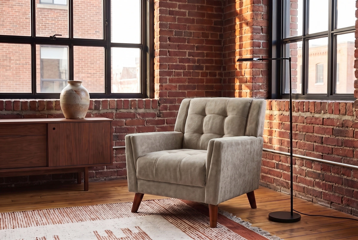 Comacchio armchair in light brown in a brick-walled loft with steel windows, a walnut sideboard and a black floor lamp