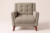 Comacchio armchair in light brown, straight front view: tufted back between two upright posts, flared track arms