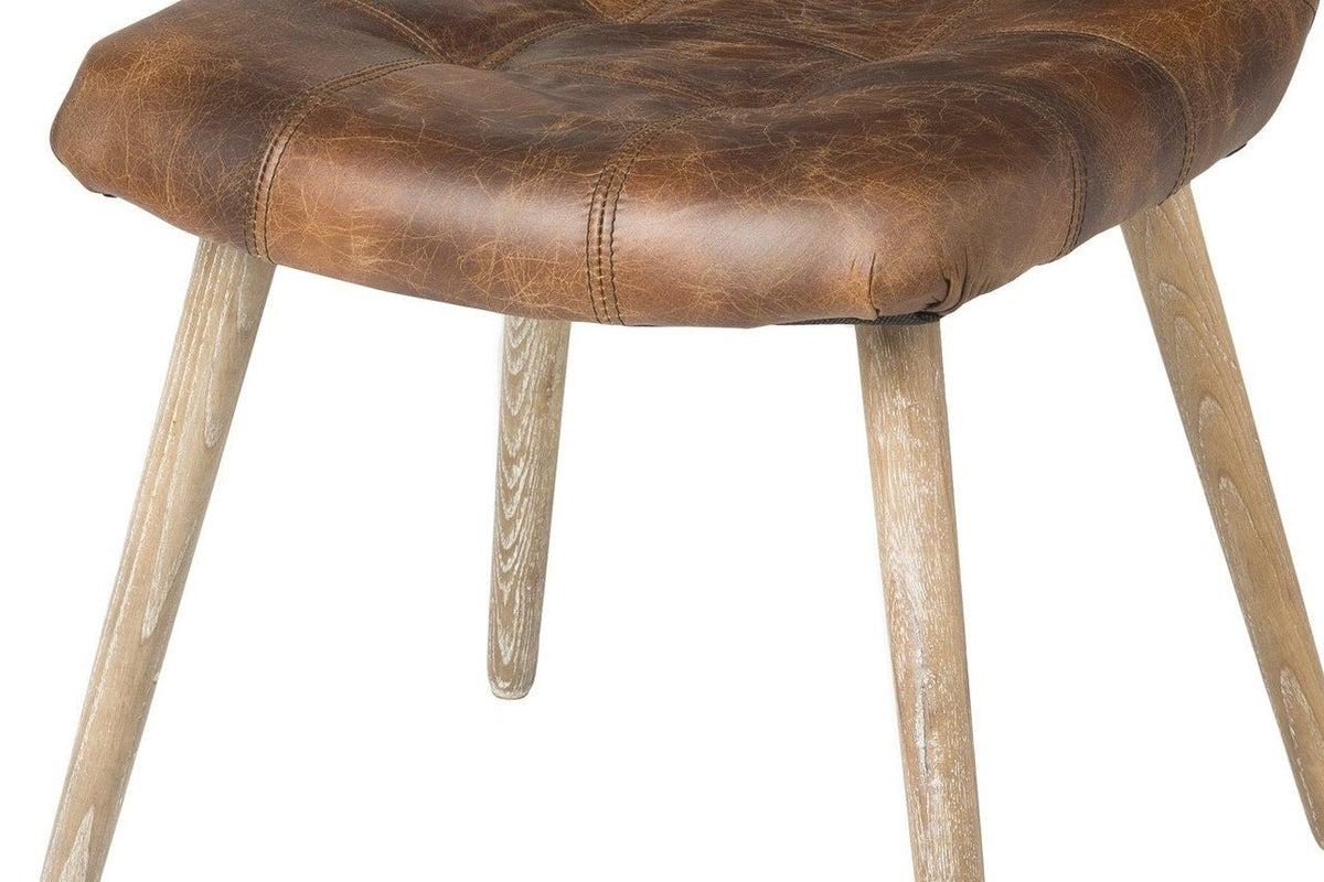 Close-up of the Compiano front roll and its seams over four splayed, tapered ash legs in a pale distressed-ash finish
