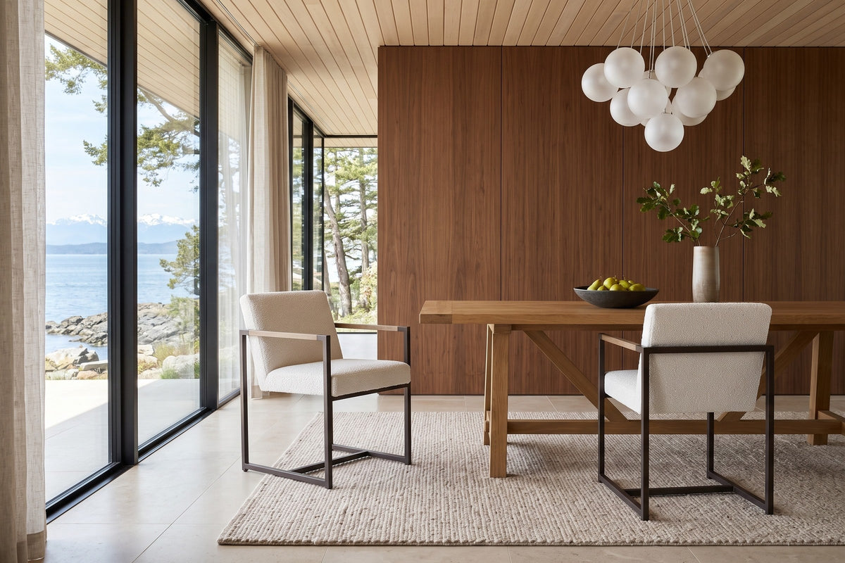 Two Coreglia dining armchairs in White at an elm trestle table in a Metchosin oceanfront house