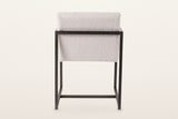 Back of the Coreglia dining armchair in White on a warm white studio backdrop: the covered back above the metal back rail