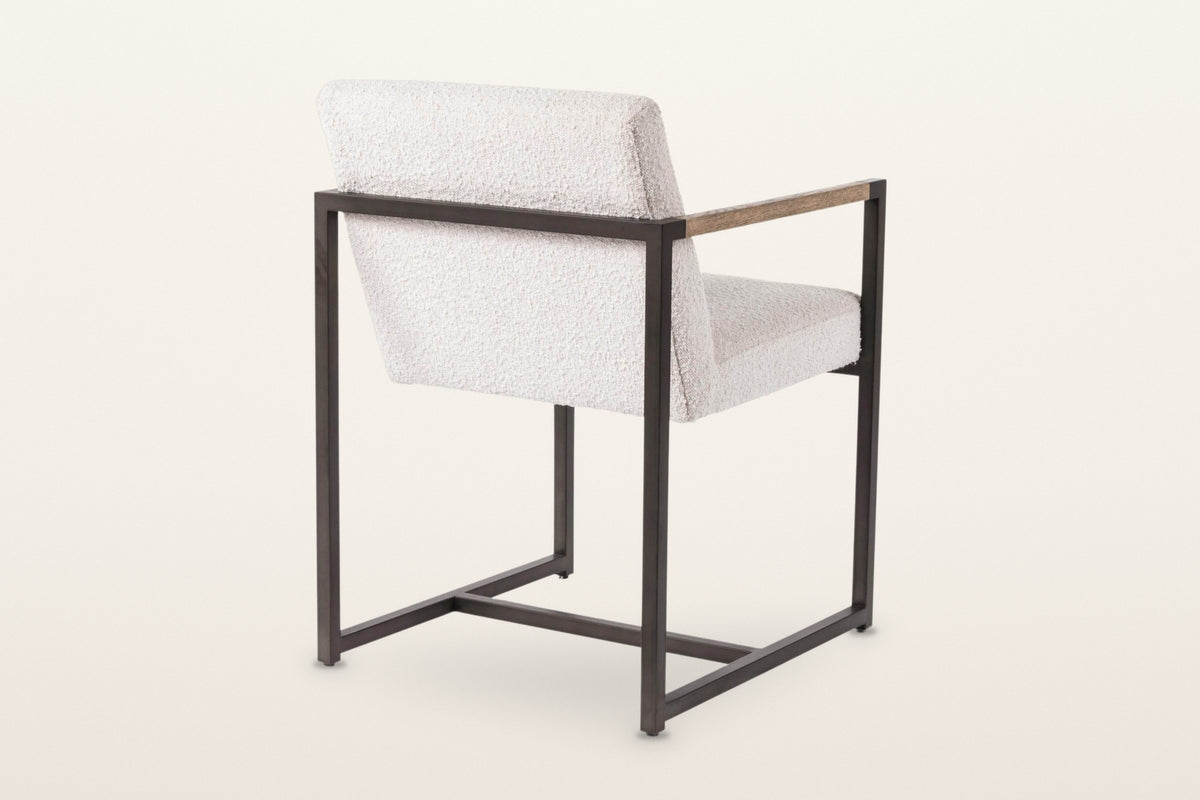 Coreglia dining armchair in White from the back at three-quarter on a warm white studio backdrop: the back rail and the cross