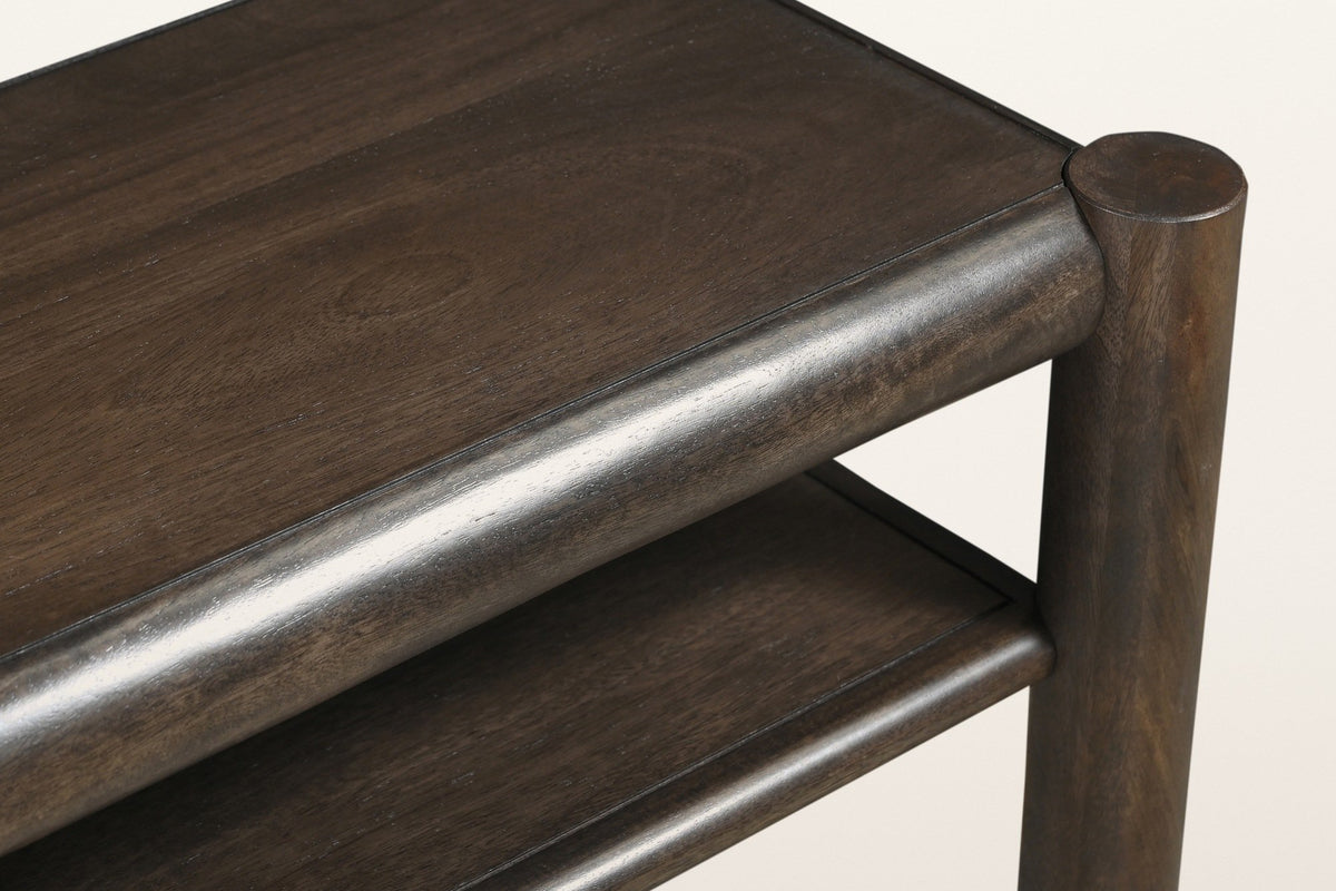 Close-up of a Corniglia top corner in mocha: the round leg top, the rounded rail and the dark espresso finish over mango grain
