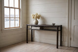 Corniglia console table in mocha against white painted boards in a Lunenburg front hall, the harbour through a six-pane window