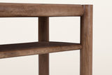 Close-up of the Corniglia console in walnut: the round top rail running into a leg, and the rounded front edge of the shelf below