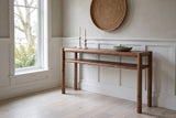 Corniglia console table in walnut against a putty-grey limewashed wall in a Victoria Craftsman entry hall, white candlesticks and a sage bowl on top