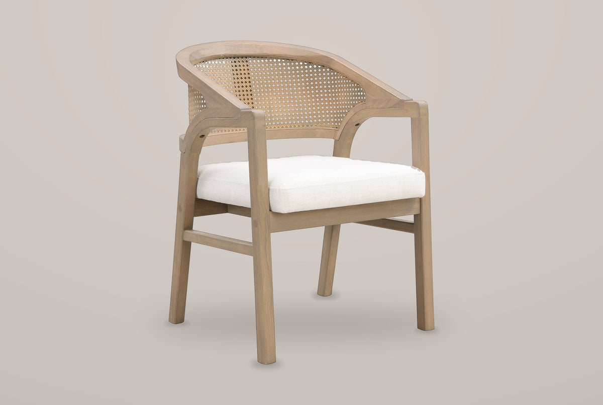 Cortina cane-back dining armchair in Light Ash, three-quarter view on a warm light-grey studio backdrop