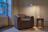 Cuneo swivel chair in a panelled Toronto townhouse corner at dusk, a brass floor lamp lit and a candle on a walnut side table