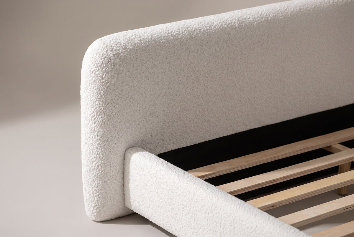 Close-up of the white boucle headboard corner with the side rail running into it