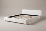 Cupello boucle platform bed in white, three-quarter view of the bare frame on a warm grey studio backdrop