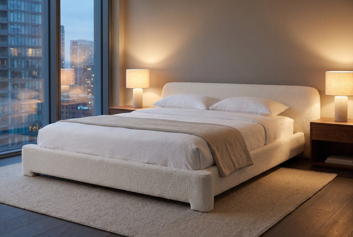 Cupello boucle bed in a city condo bedroom at dusk with two lamps lit