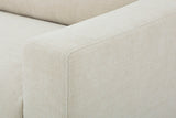 Close-up of the Cupramontana arm in Beige: the softly rounded front corner of the arm and the woven polyester