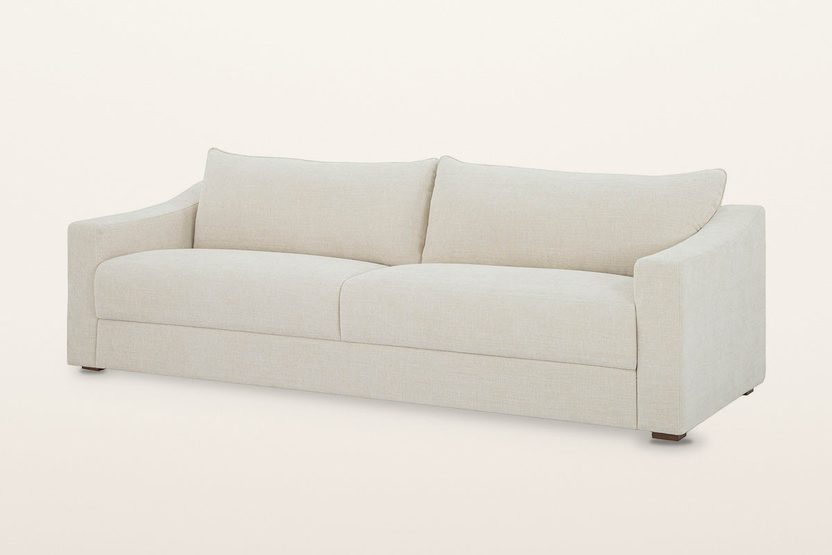 Cupramontana sofa in Beige, three-quarter view on a warm white studio backdrop: scooped arms with flat fronts