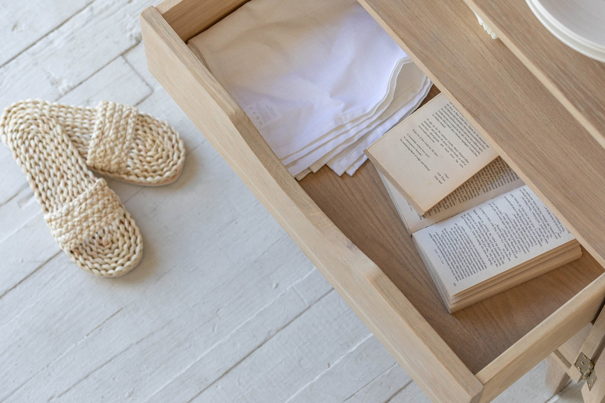 Dalton cabinet oak drawer open with folded linens and a book