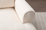 Close-up of the ivory sherpa: the round face of the rolled arm with its welt edge, beside the deep seat