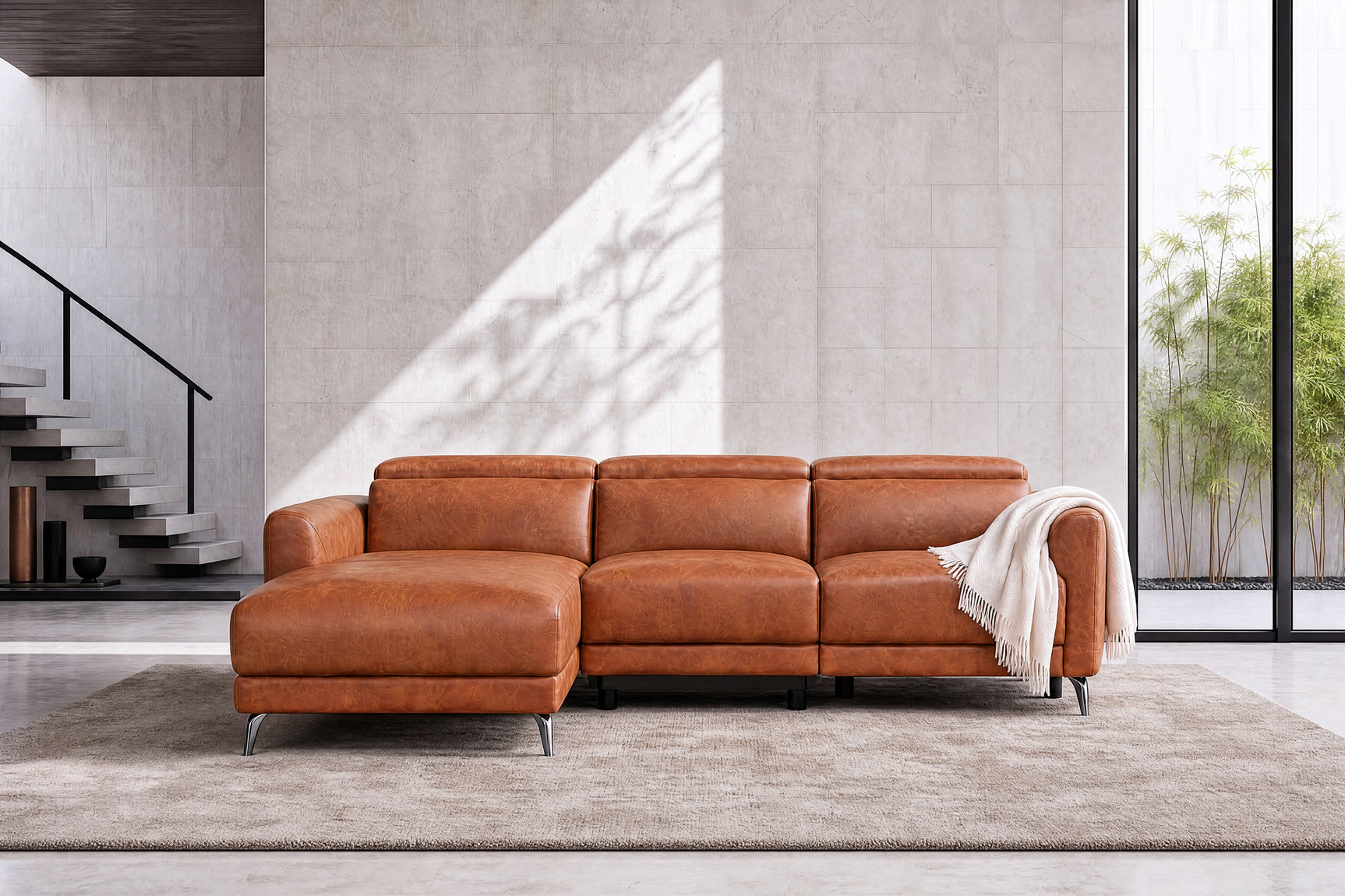 Front view of the Andria cognac leather sectional with left-facing chaise in a minimalist interior