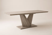 Ellis extendable dining table in Washed Oak, three-quarter view on a warm off-white studio backdrop: a bevelled top on one V