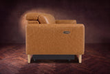 The left end of the Elodie sofa seen from the side on a dark walnut herringbone floor, the control panel on the arm and the headrest raised. Shown in Antiqued Caramel, 3 seat.