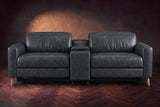 The Elodie sofa with console seen from the front in Aged Slate distressed full leather on a dark herringbone floor, headrests down and footrests closed.