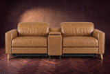 The Elodie sofa with console seen from the front in Antiqued Caramel distressed full leather on a dark herringbone floor, headrests down and footrests closed.