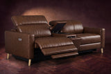 The Elodie sofa with console in Burnished Chestnut distressed full leather on a dark herringbone floor, the left seat reclined with its two-part footrest out and its headrest raised, the console lid open.