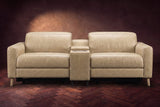 The Elodie sofa with console seen from the front in Washed Sand distressed full leather on a dark herringbone floor, headrests down and footrests closed.