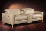 The Elodie sofa with console in Washed Sand distressed full leather on a dark herringbone floor, headrests down and footrests closed.