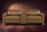The Elodie sofa with console seen from the front in Weathered Saddle distressed full leather on a dark herringbone floor, headrests down and footrests closed.