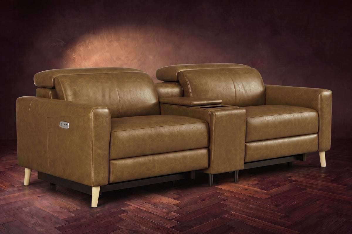 The Elodie sofa with console in Weathered Saddle distressed full leather on a dark herringbone floor, headrests down and footrests closed.