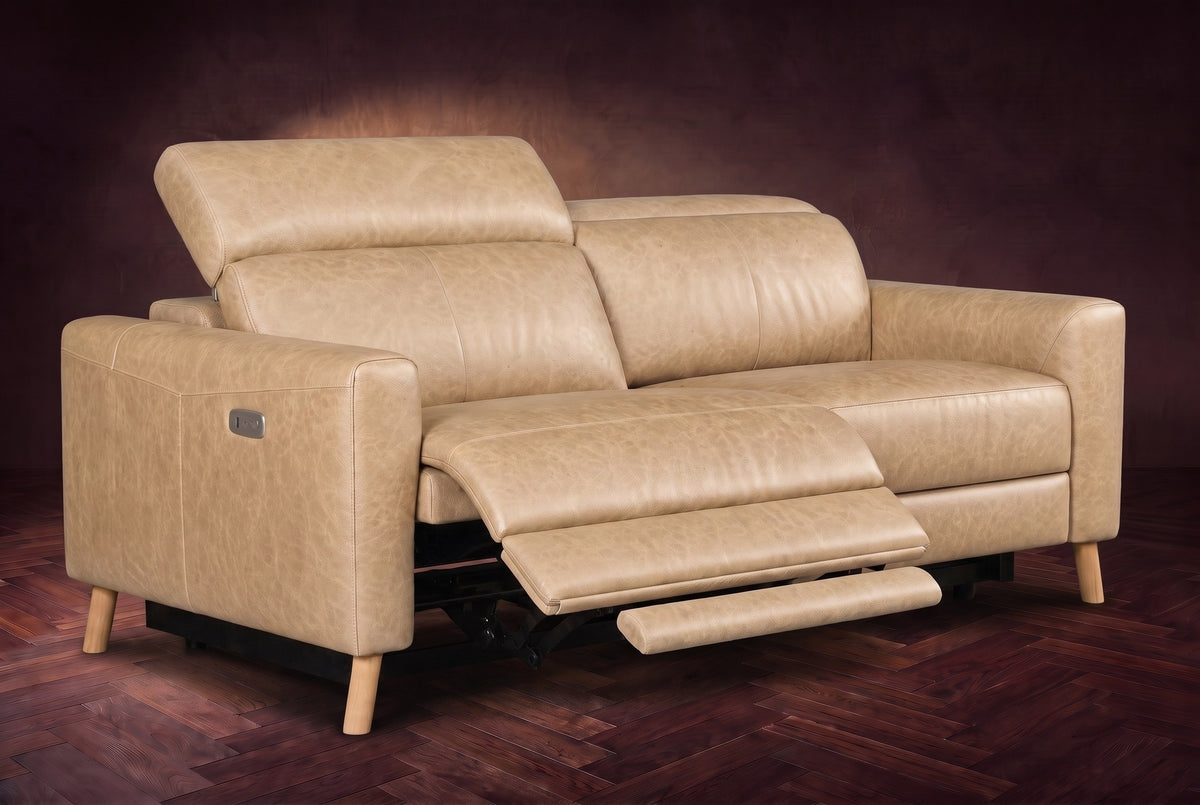 The Elodie loveseat on a dark walnut herringbone floor, the left seat reclined with its footrest out and its headrest raised. Shown in Washed Sand, Loveseat.