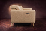 The left end of the Elodie sofa seen from the side on a dark walnut herringbone floor, the control panel on the arm and the headrest raised. Shown in Washed Sand, 3 seat.